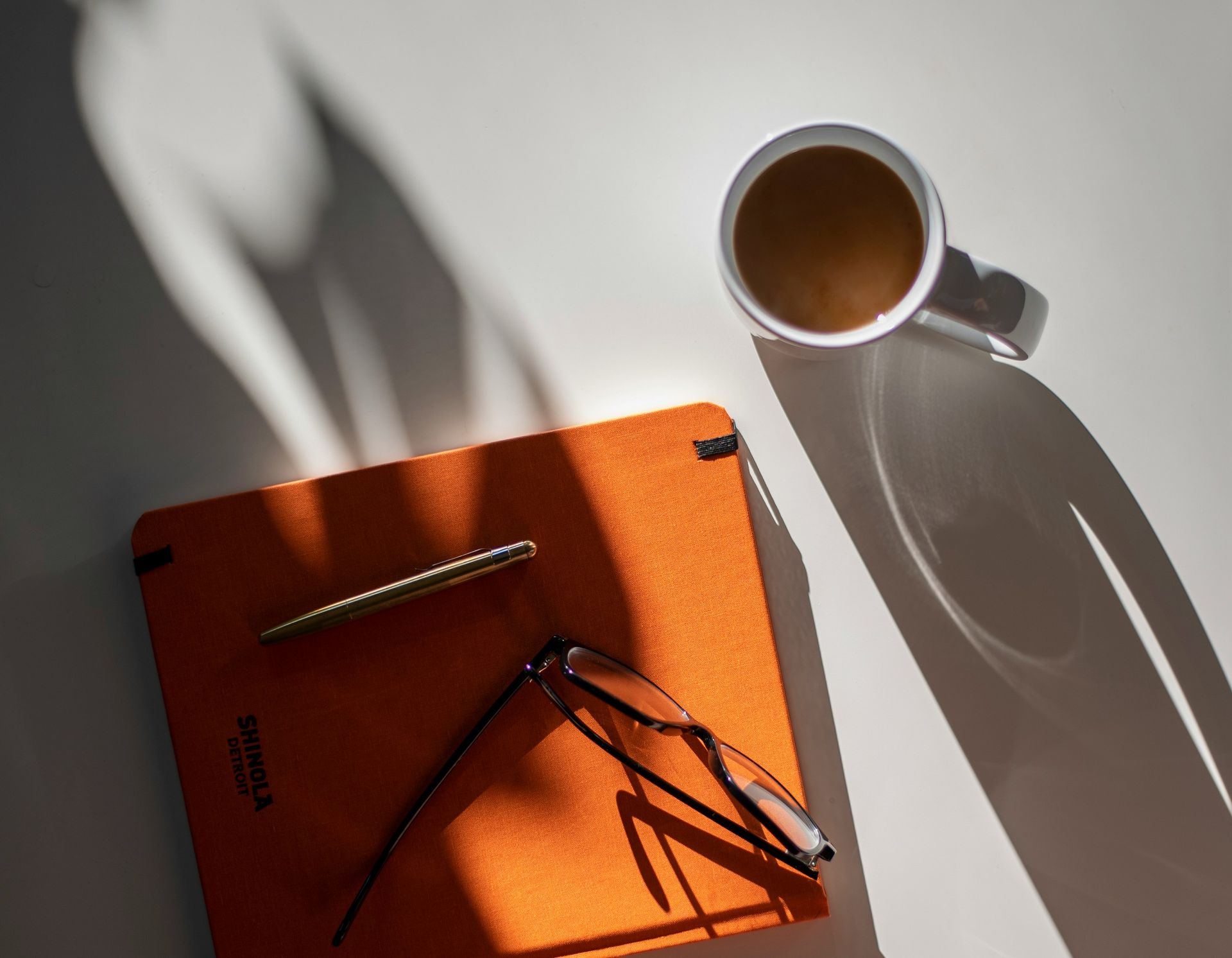 minimal workspace with coffe and orange planner
