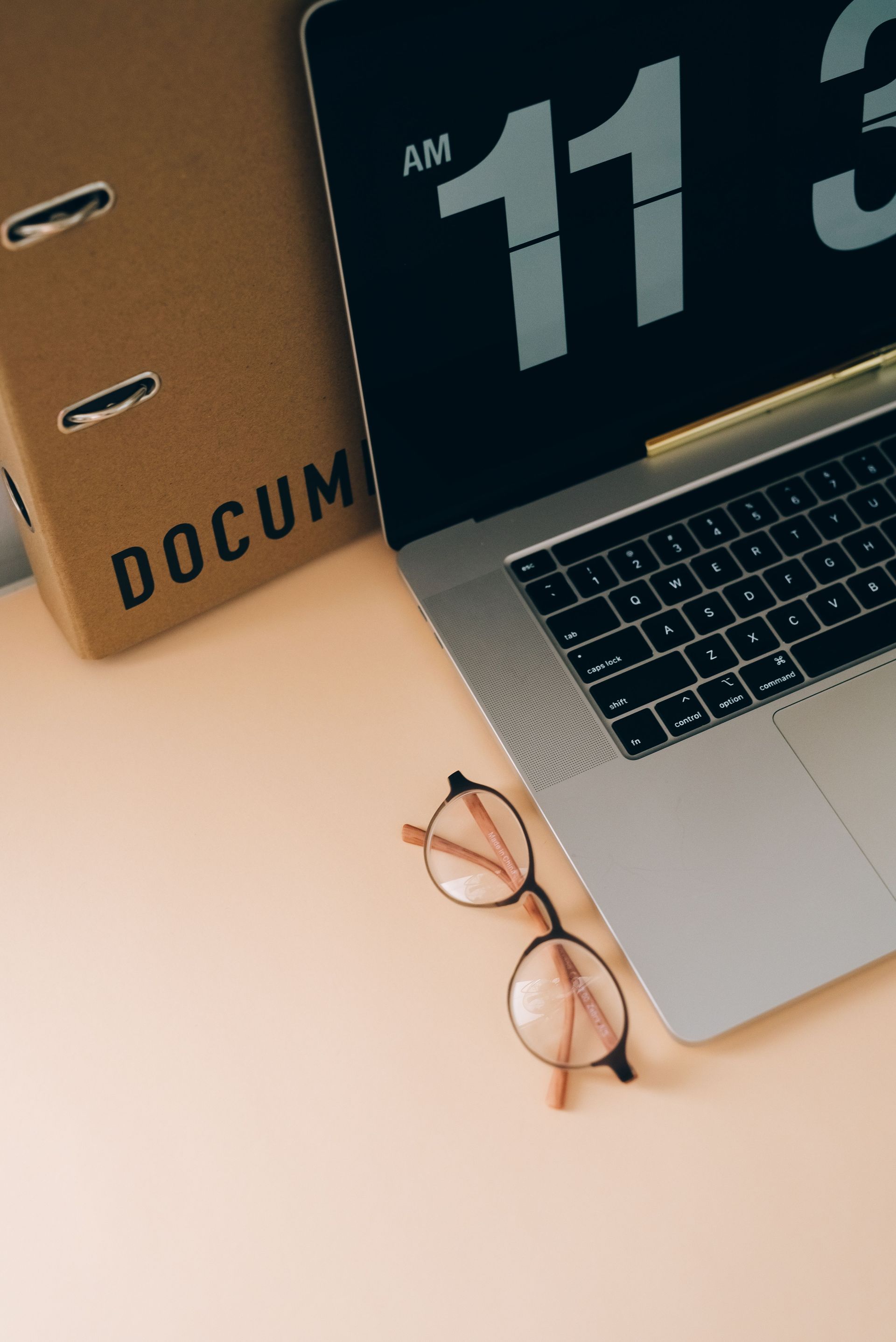 beige workspace with laptop and glasses
