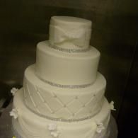 White multi-tiered wedding cake with decorative icing and ribbon details