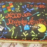 Colorful Pac-Man-themed birthday cake with “Happy 30th Birthday Avetta” and “I ♥ the 80s” icing text