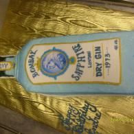 Bottle of Bombay Sapphire Dry Gin on gold fabric, label centered and slightly tilted.