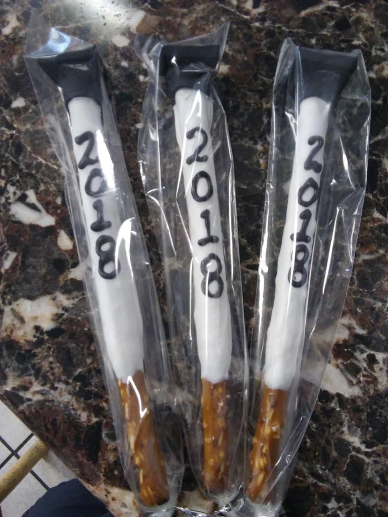 Three wrapped pens with white barrels, black tops, and brown woodgrain handles, labeled “2018”