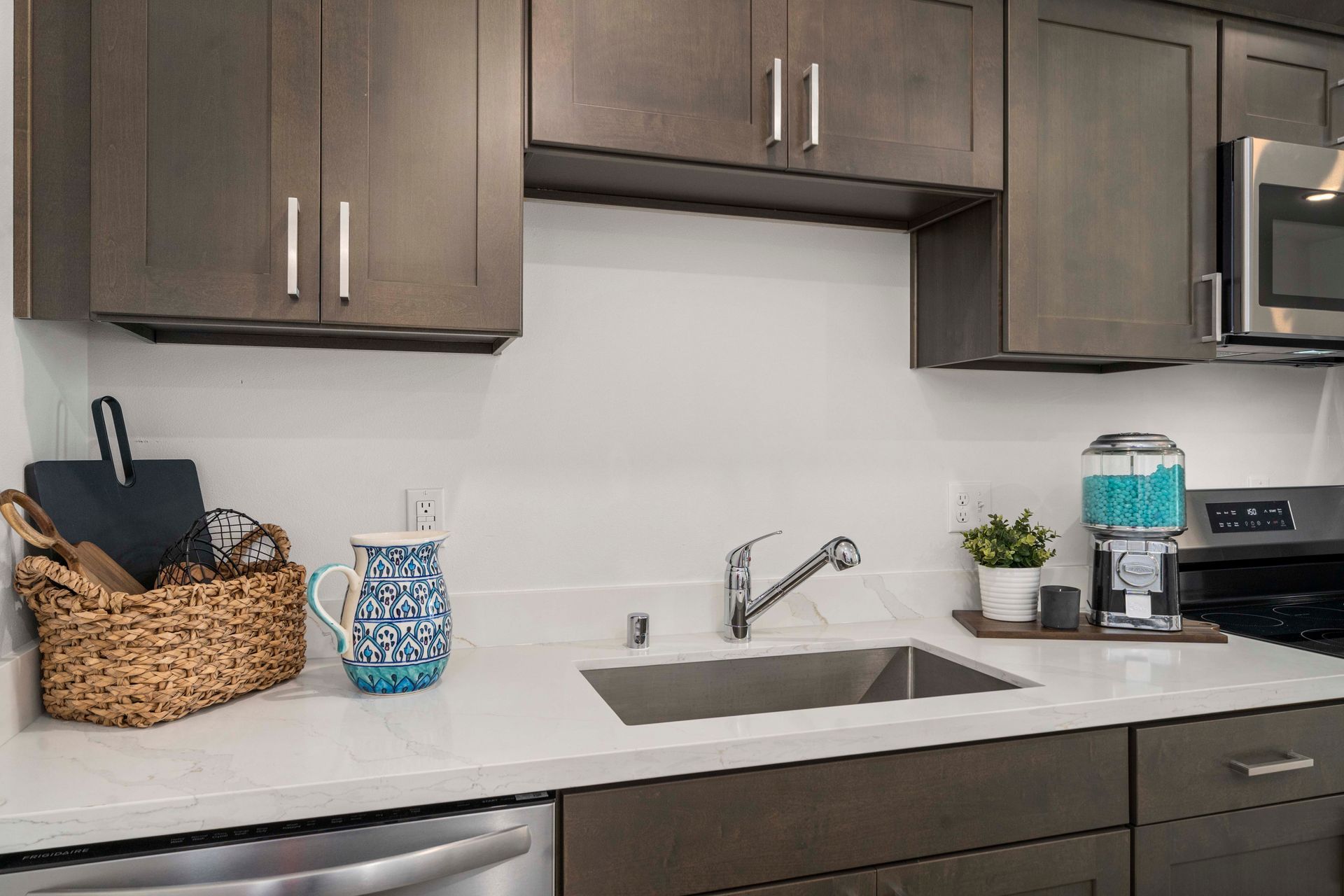 Kitchen sink and countertop area with dark cabinets at Blueberry Apartments Port Orchard.