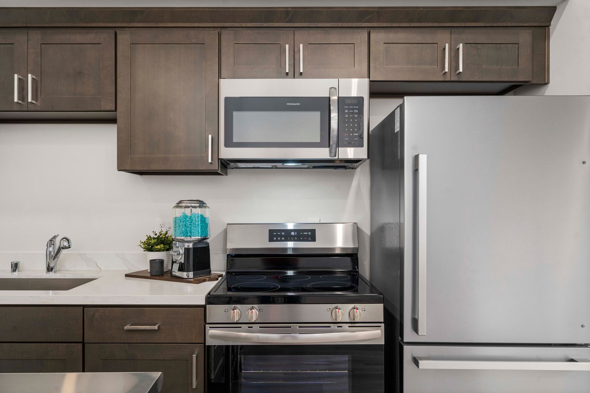 Kitchen with stainless steel refrigerator, microwave, and oven at Blueberry Apartments Port Orchard.