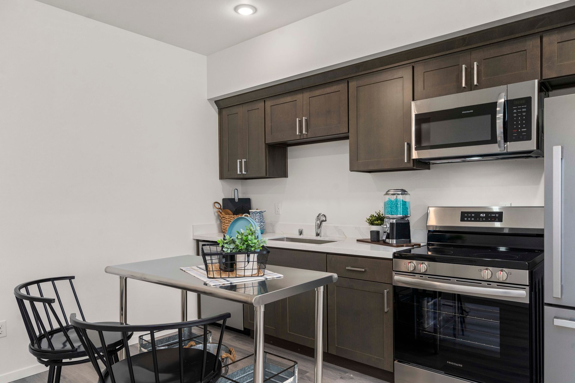 Kitchen with stainless steel refrigerator and dark cabinets at Blueberry Apartments Port Orchard.