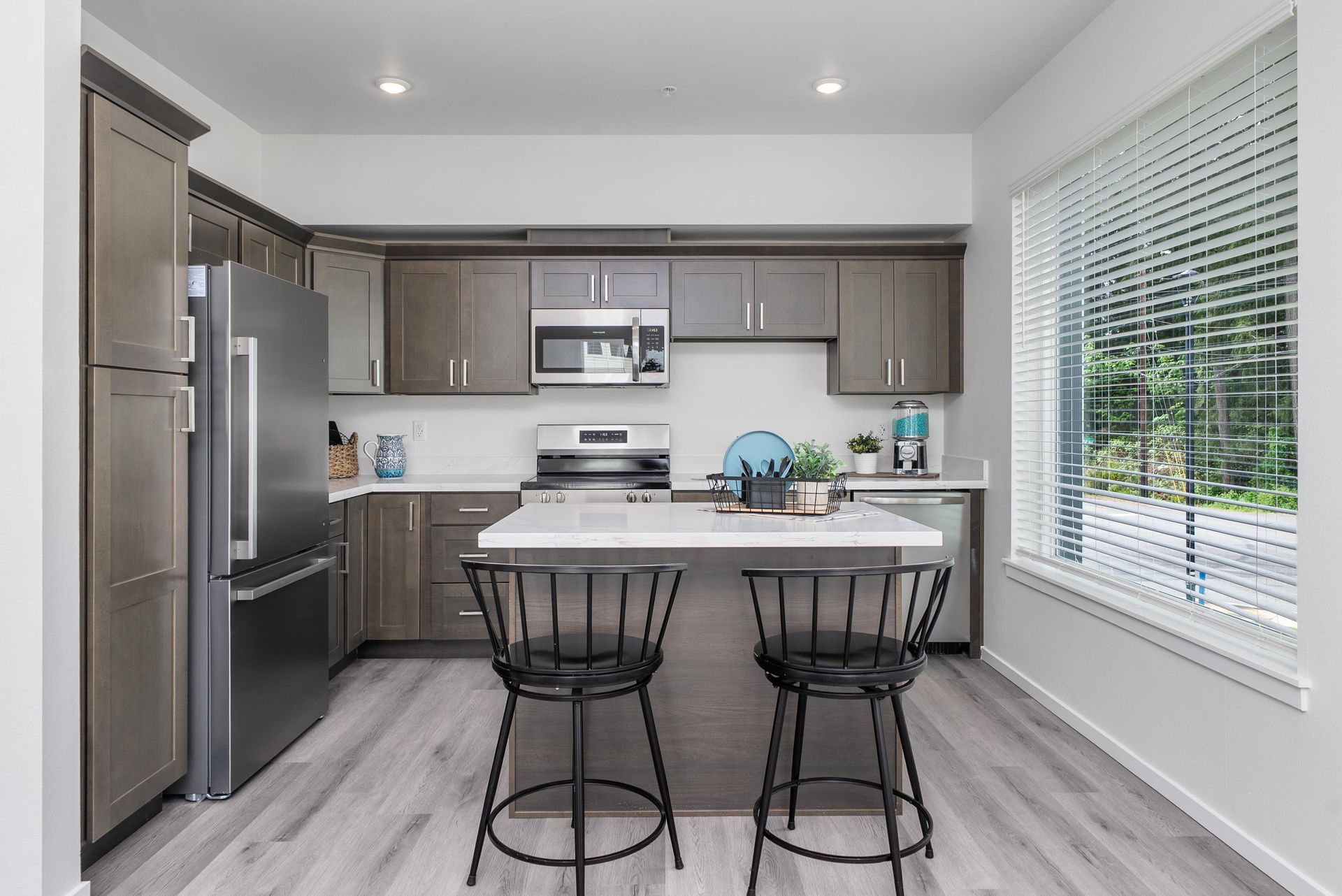 Kitchen with island, stainless steel appliances, and dark cabinets at Blueberry Apartments Port Orchard