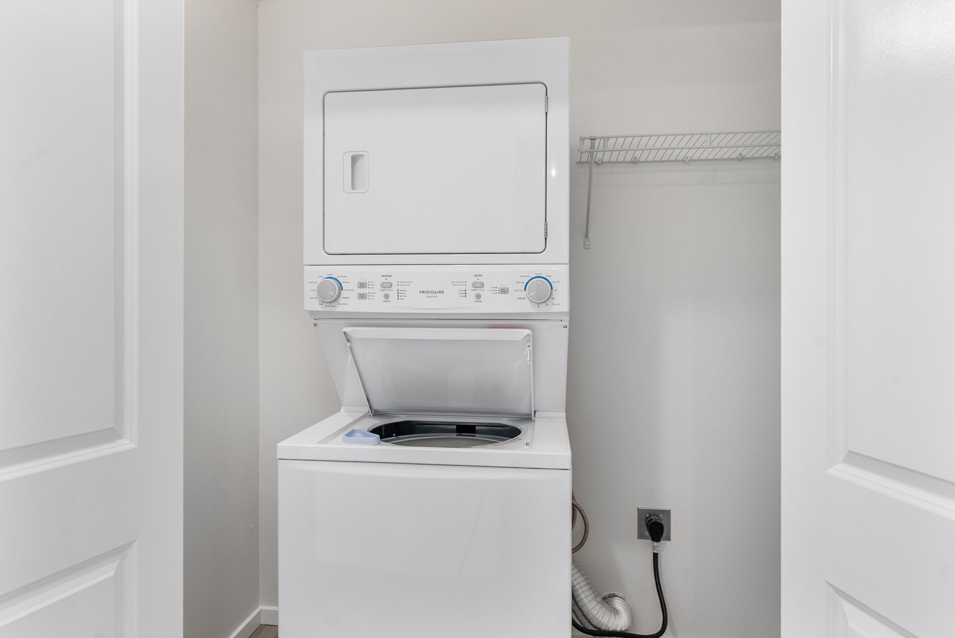 In-unit stackable washer and dryer in a clean, modern laundry closet at Blueberry Apartments.