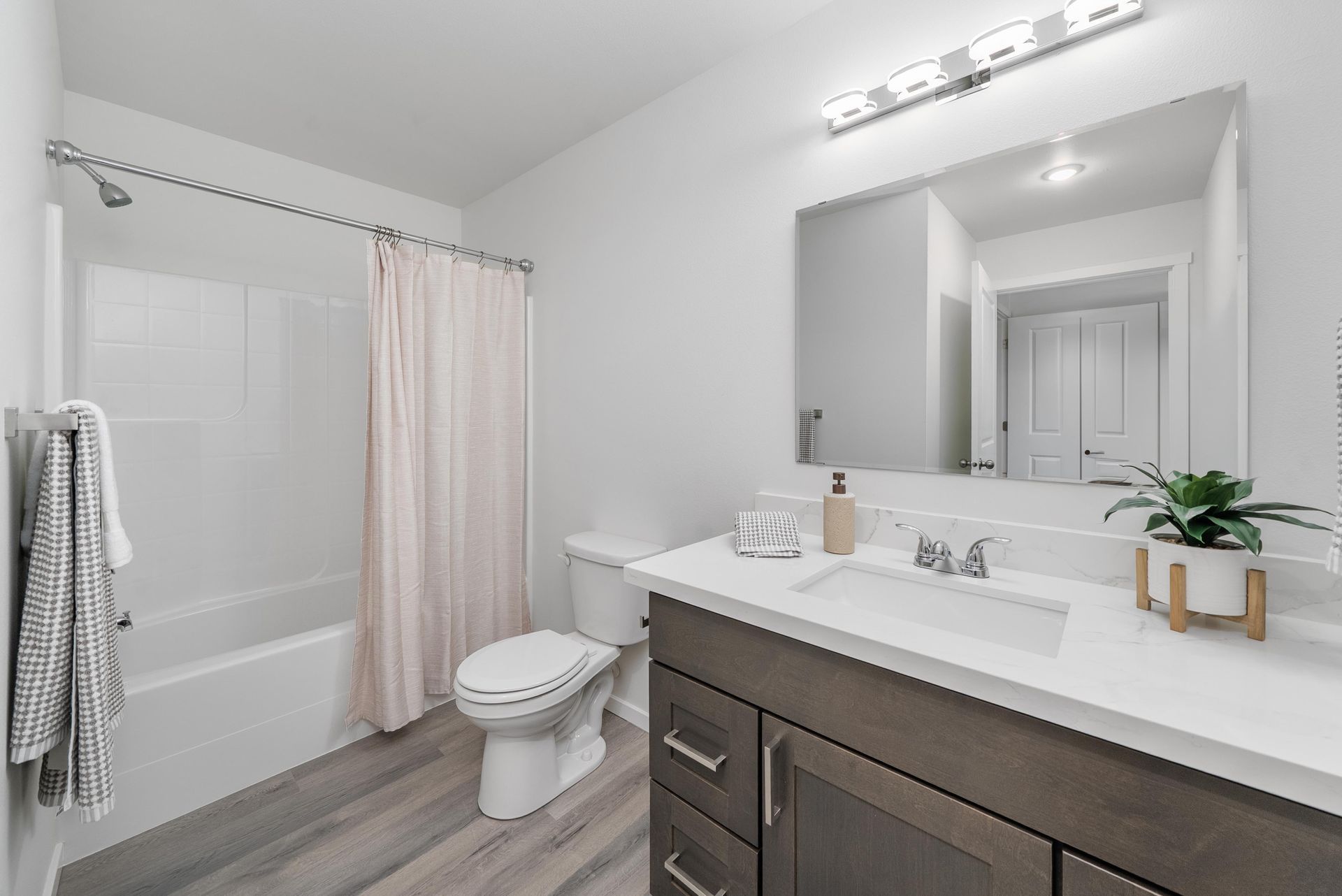 Bathroom with large vanity mirror and shower/tub at Blueberry Apartments Port Orchard