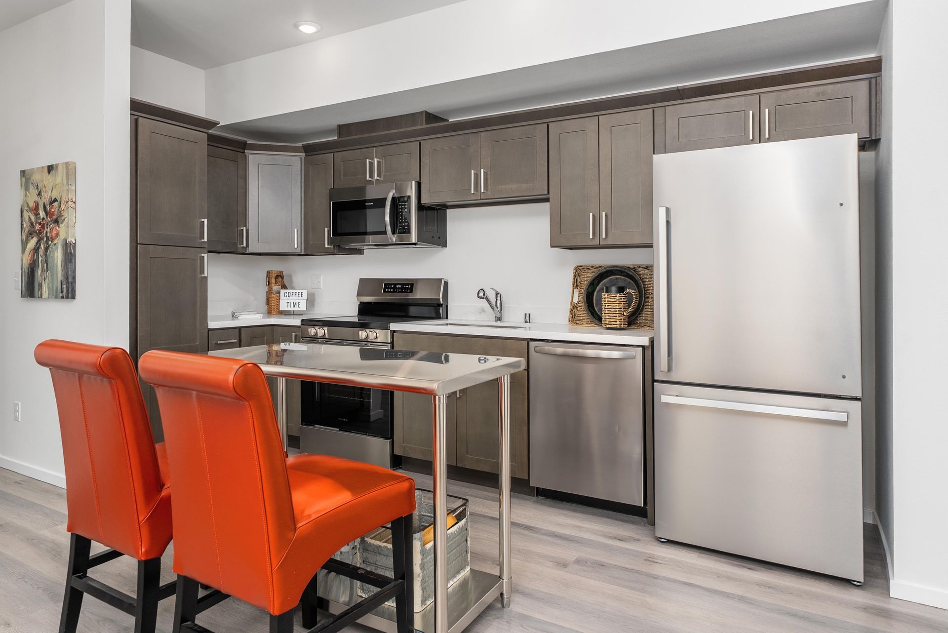 Modern kitchen with stainless steel appliances and island with seating at Blueberry Apartments Port Orchard rentals