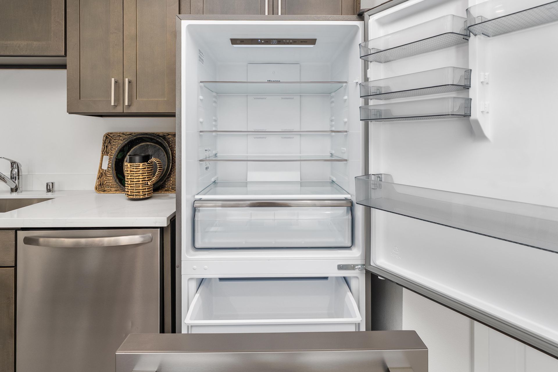 Open refrigerator showing stainless steel finish inside a Blueberry Apartments kitchen in Port Orchard