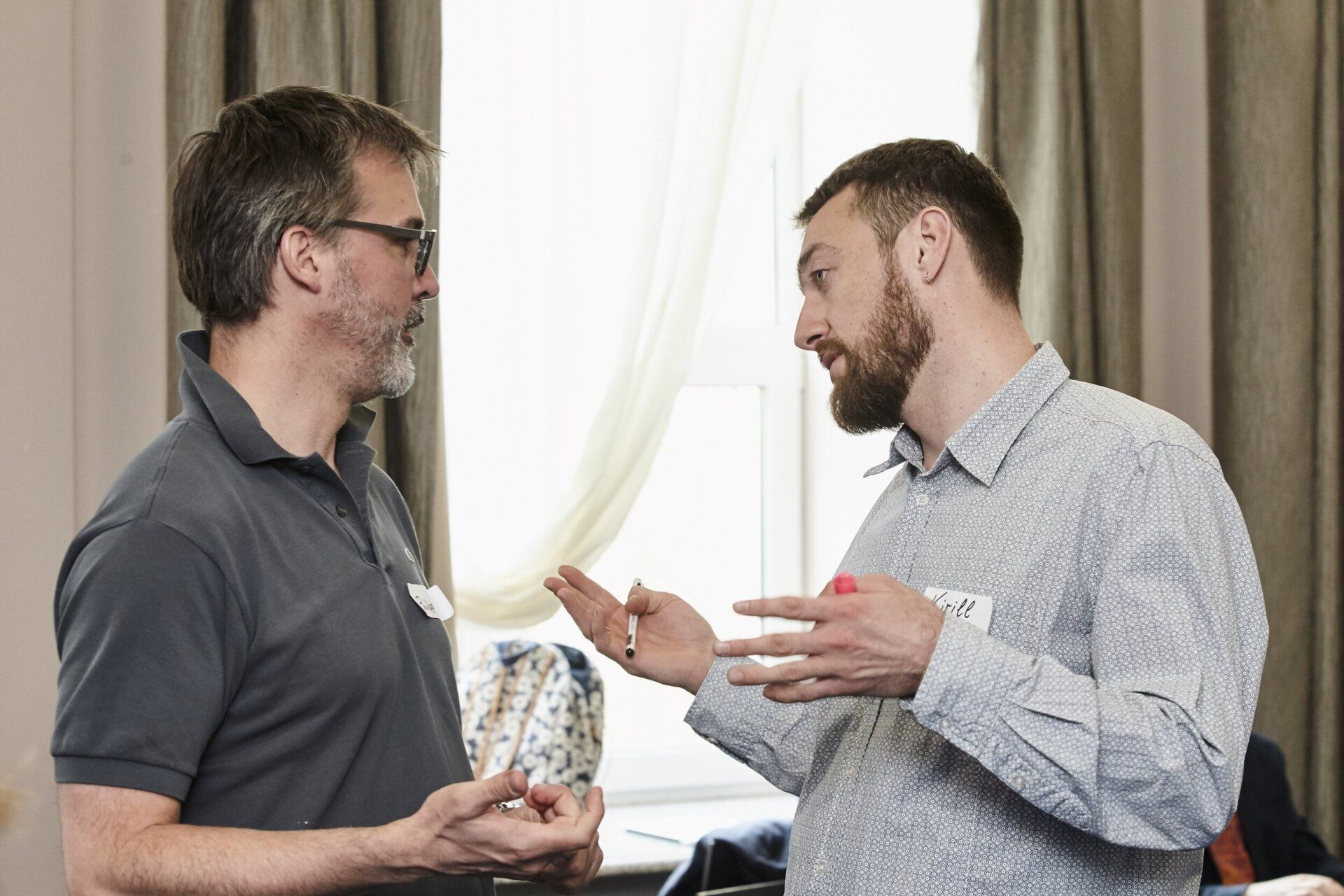 Two men are talking to each other in a room.
