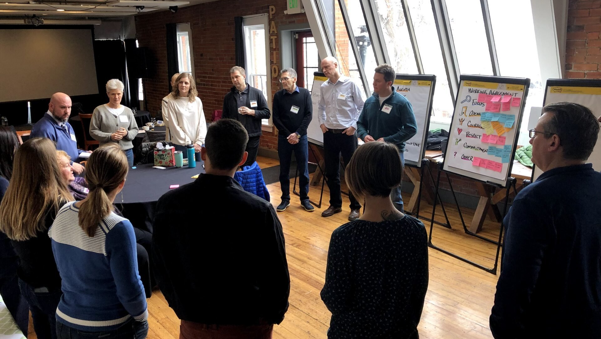 A group of people are standing around a table in a room.