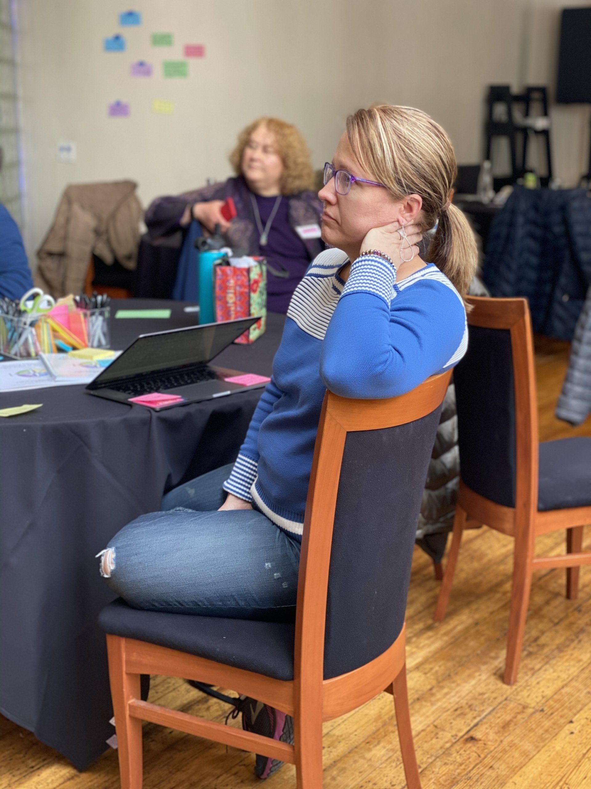 A woman in a blue sweater is sitting in a chair