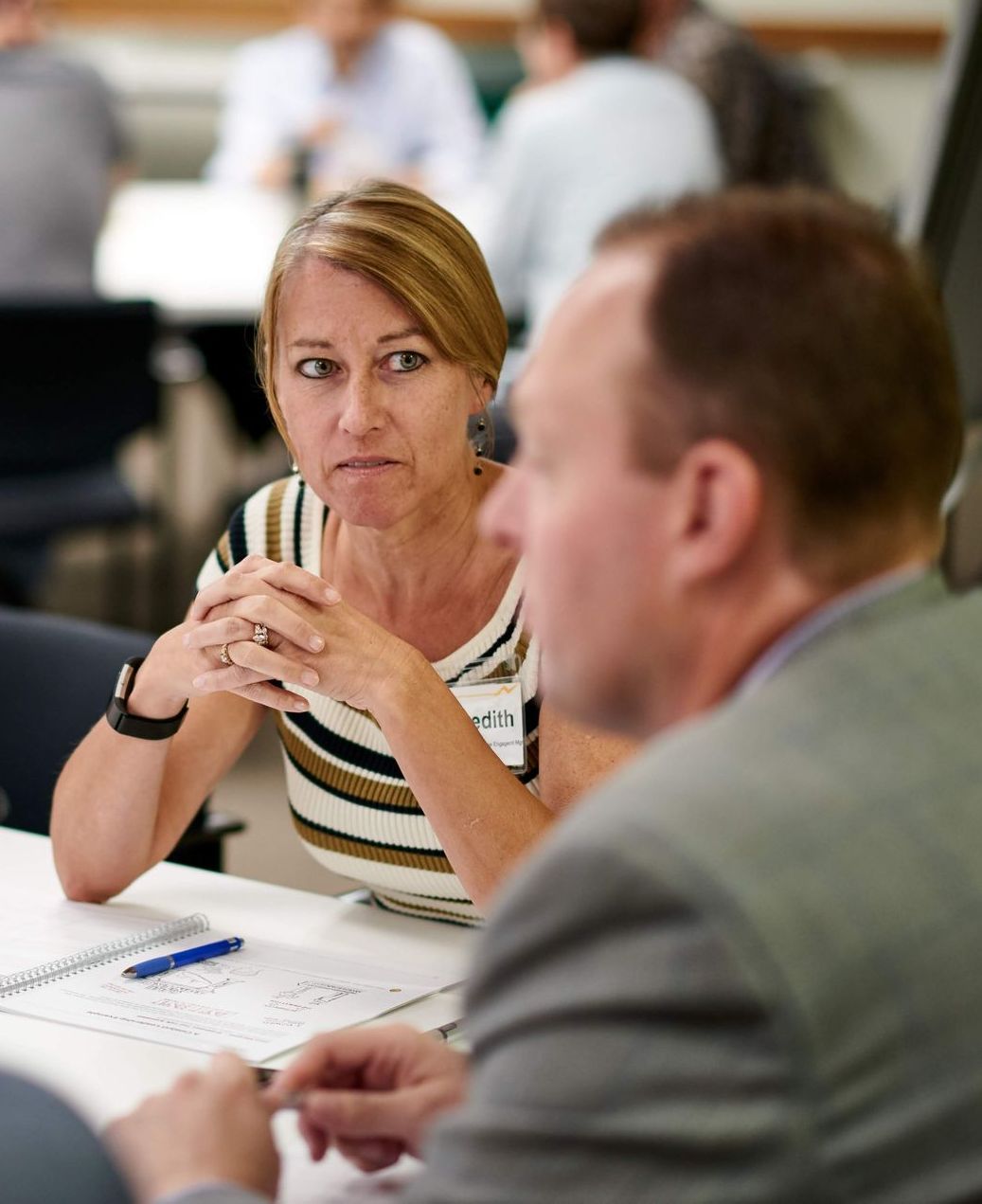A man and a woman are sitting at a table talking