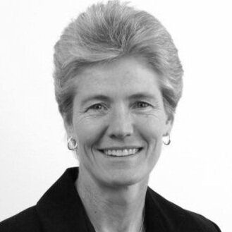 A woman is smiling in a black and white photo.