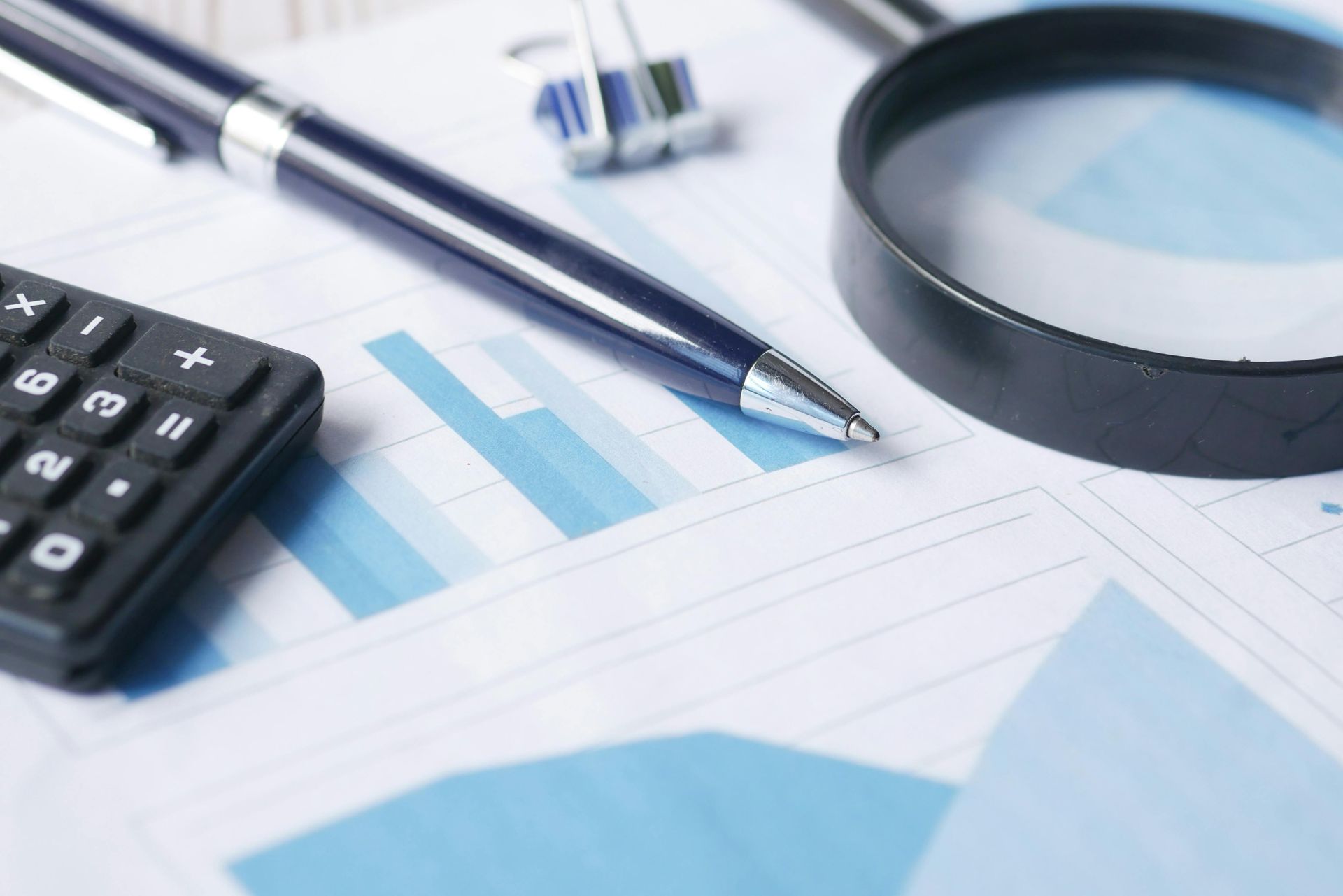 Business documents, calculator, pen, magnifying glass representing procurement analysis and review