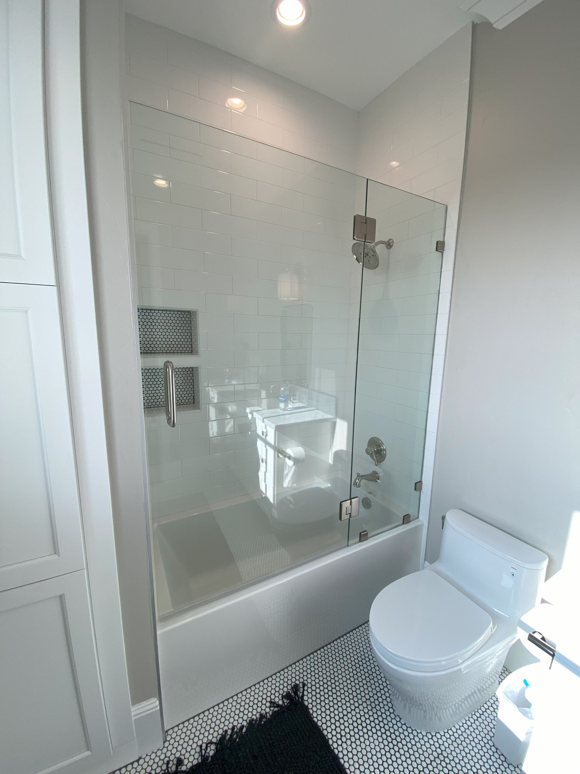 Precision glass shower enclosure by Glassology with tight seams and polished hardware
