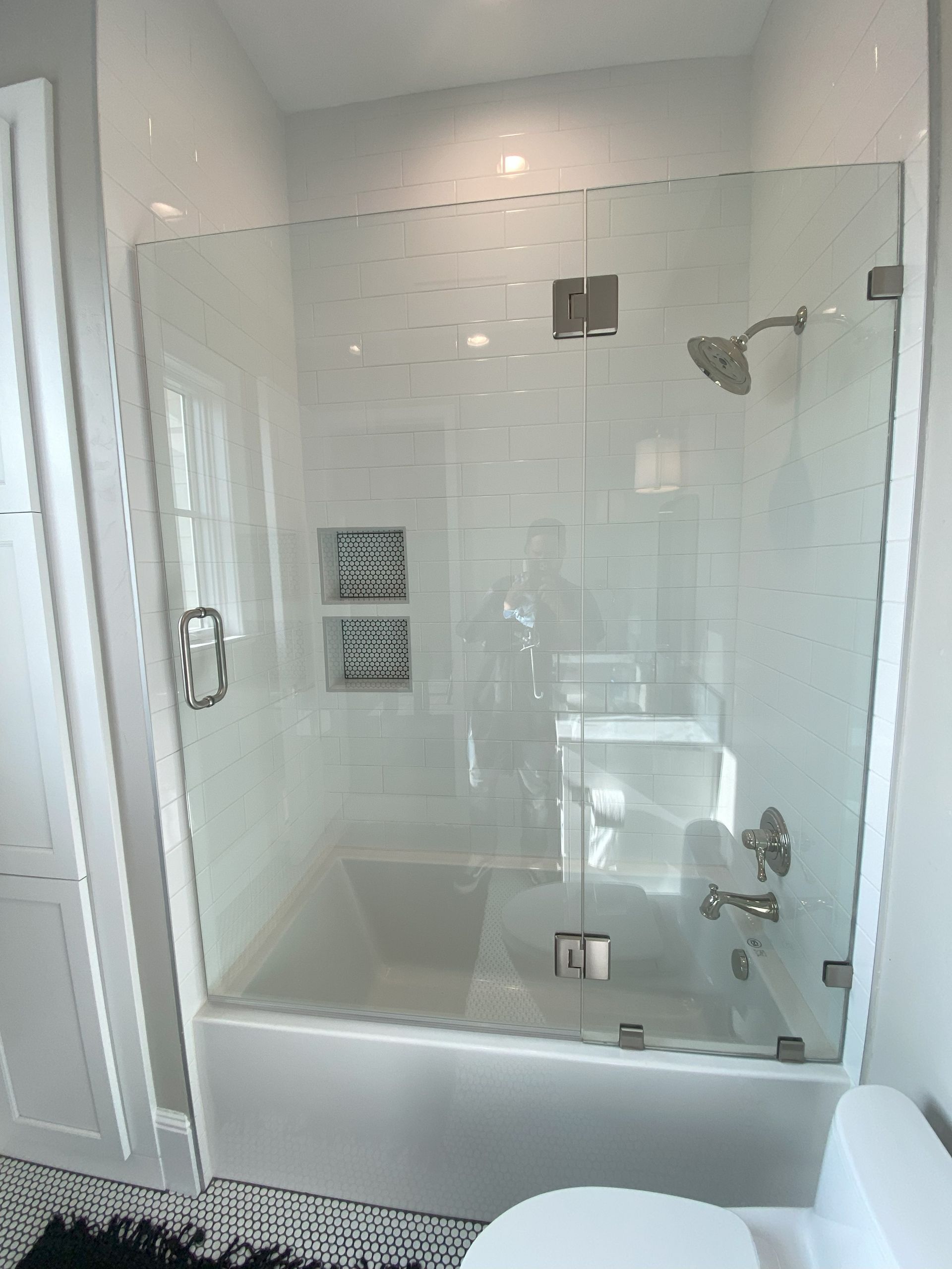 Precision glass shower enclosure by Glassology with tight seams and polished hardware
