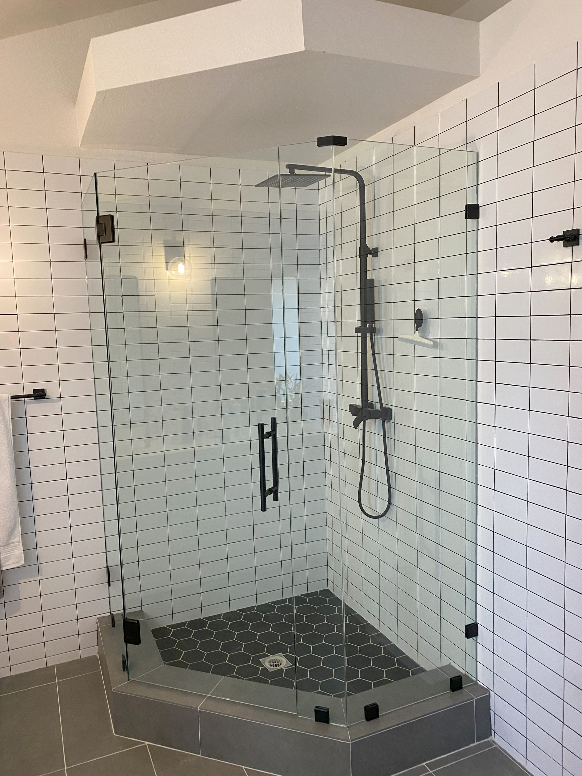 Custom glass shower by Glassology with engineered fittings and balanced panel alignment
