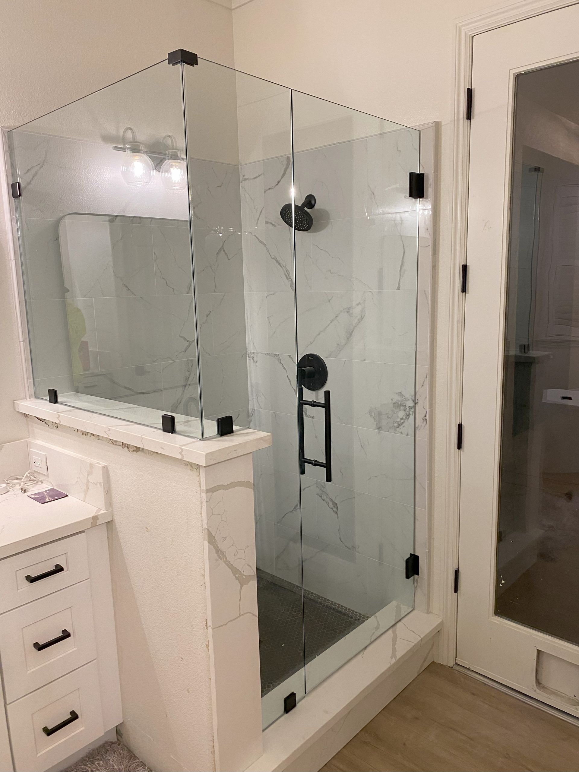 Precision glass shower enclosure by Glassology with tight seams and polished hardware
