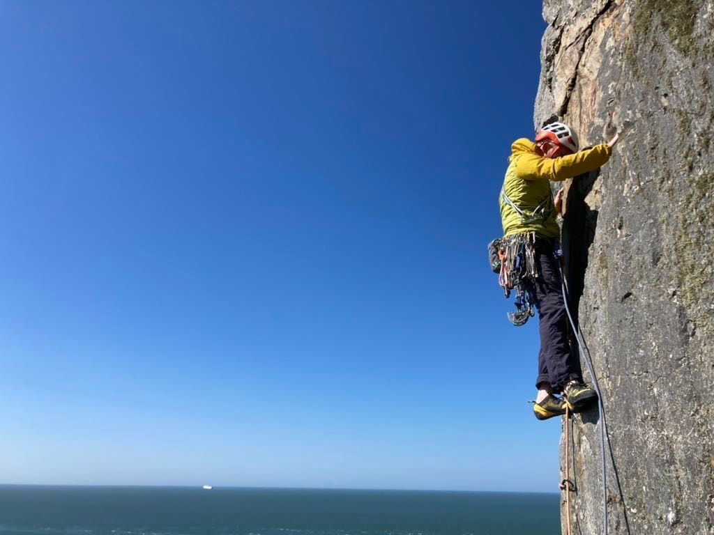 Climber on prow with sky in background