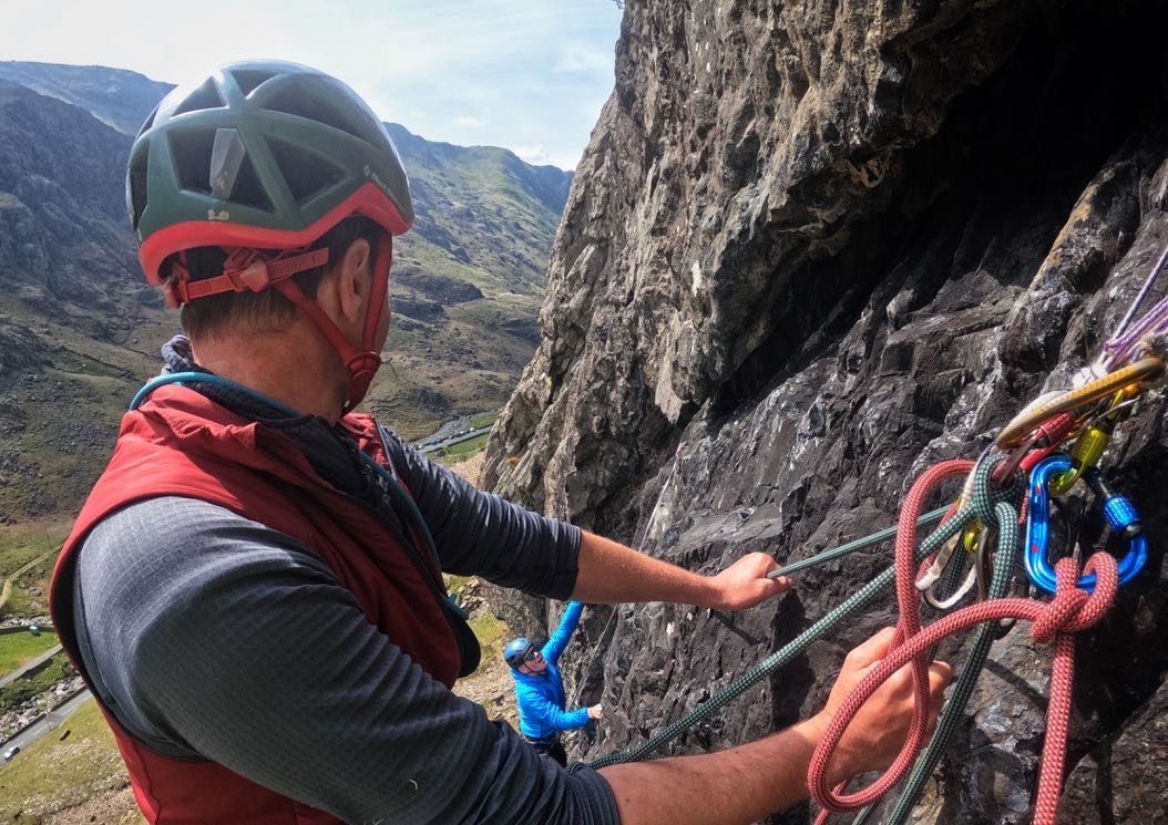Climber with helmet on with ropes belaying climber