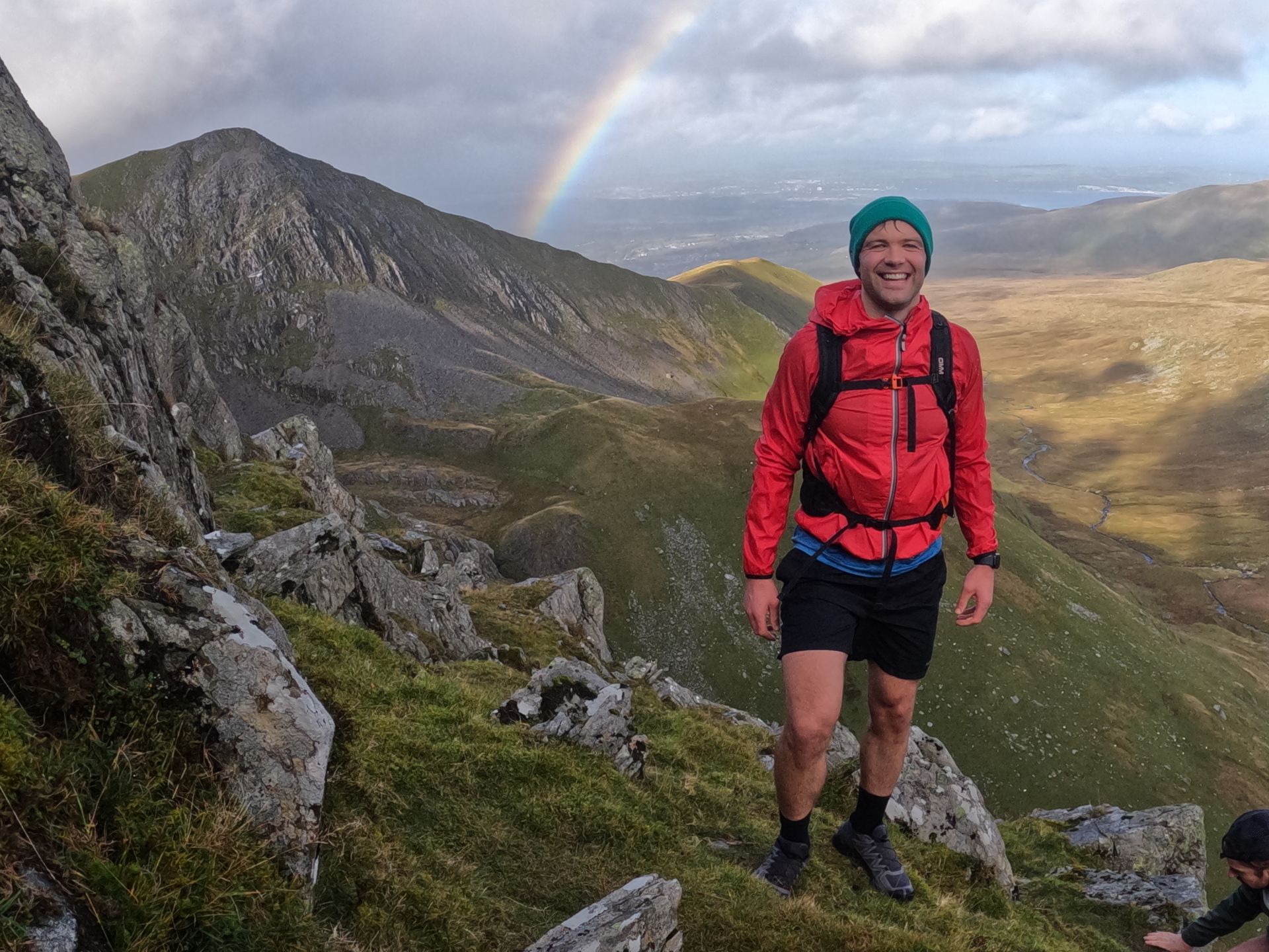 Trail runner with rainbow in background