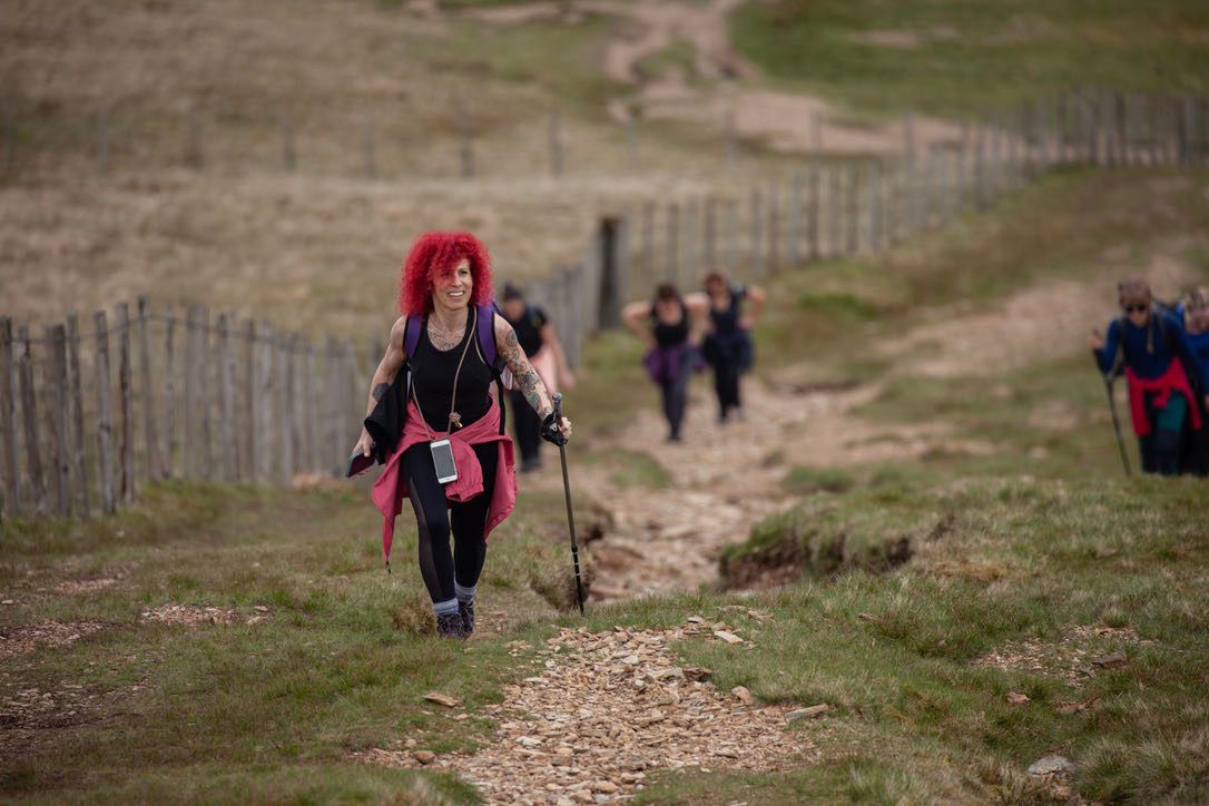 Walker with red hair walking up a track