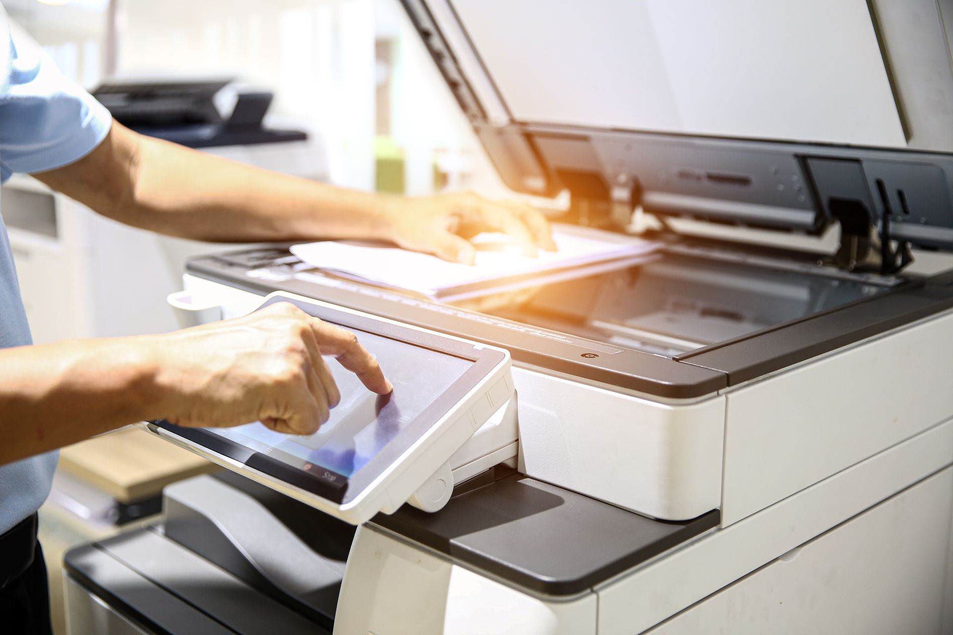 a person operating a multifunction printer in an office setting.