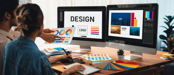A man is using a laptop computer to design a logo.