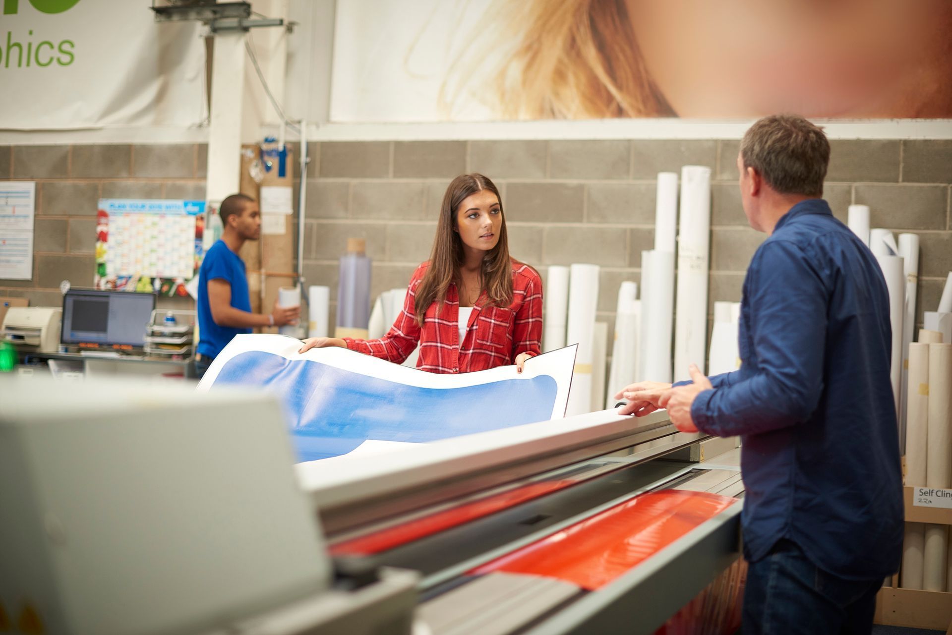 A woman is working on a digital printing machine.