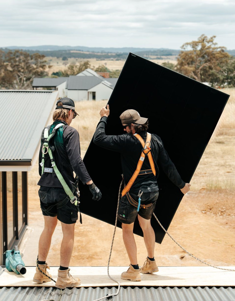 Technicians carrying solar panels for residential install