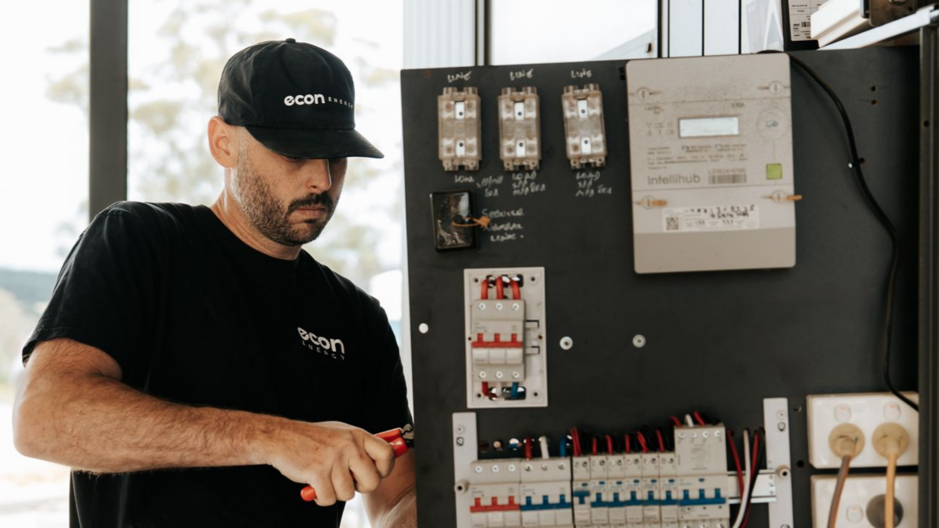 Electrician installing solar system switchboard and wiring