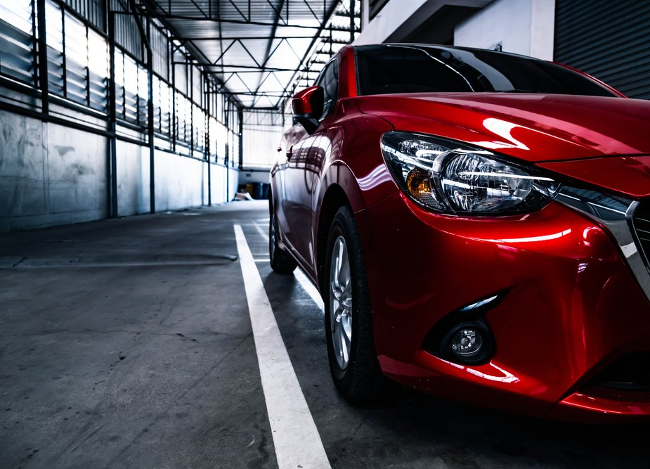 Red car parked in an indoor garage.