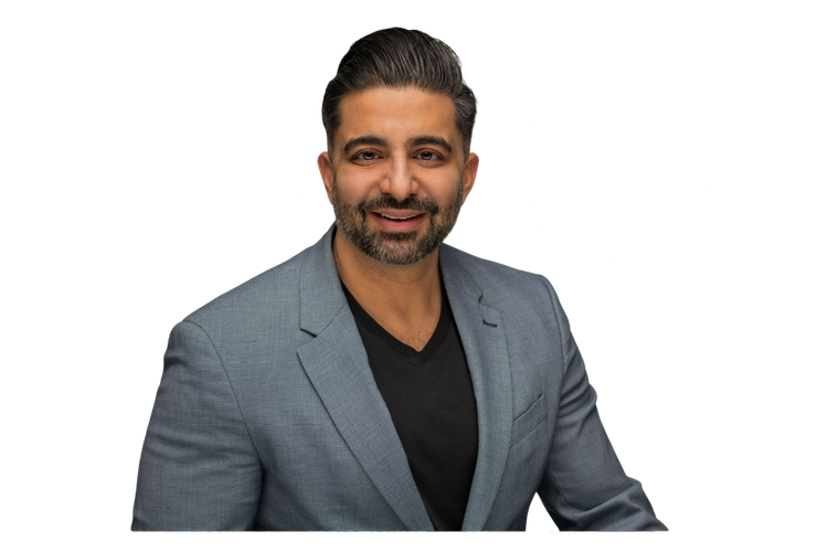 A man in a suit and black shirt is smiling for the camera.