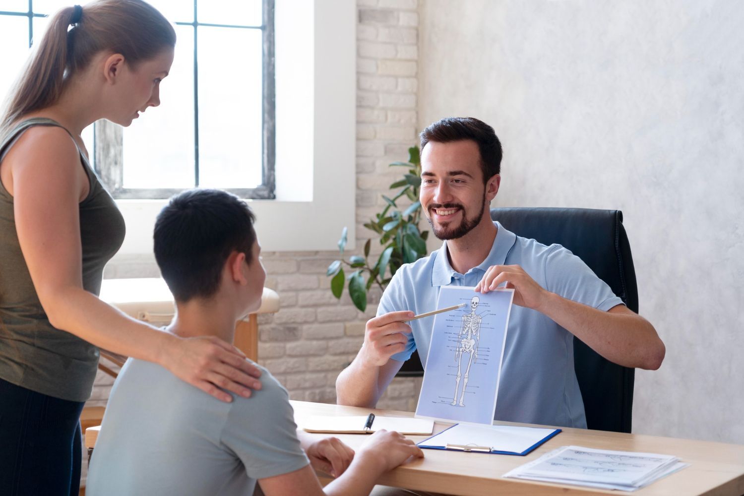 Three people discuss a document in a bright office, with one man holding up a page and smiling.