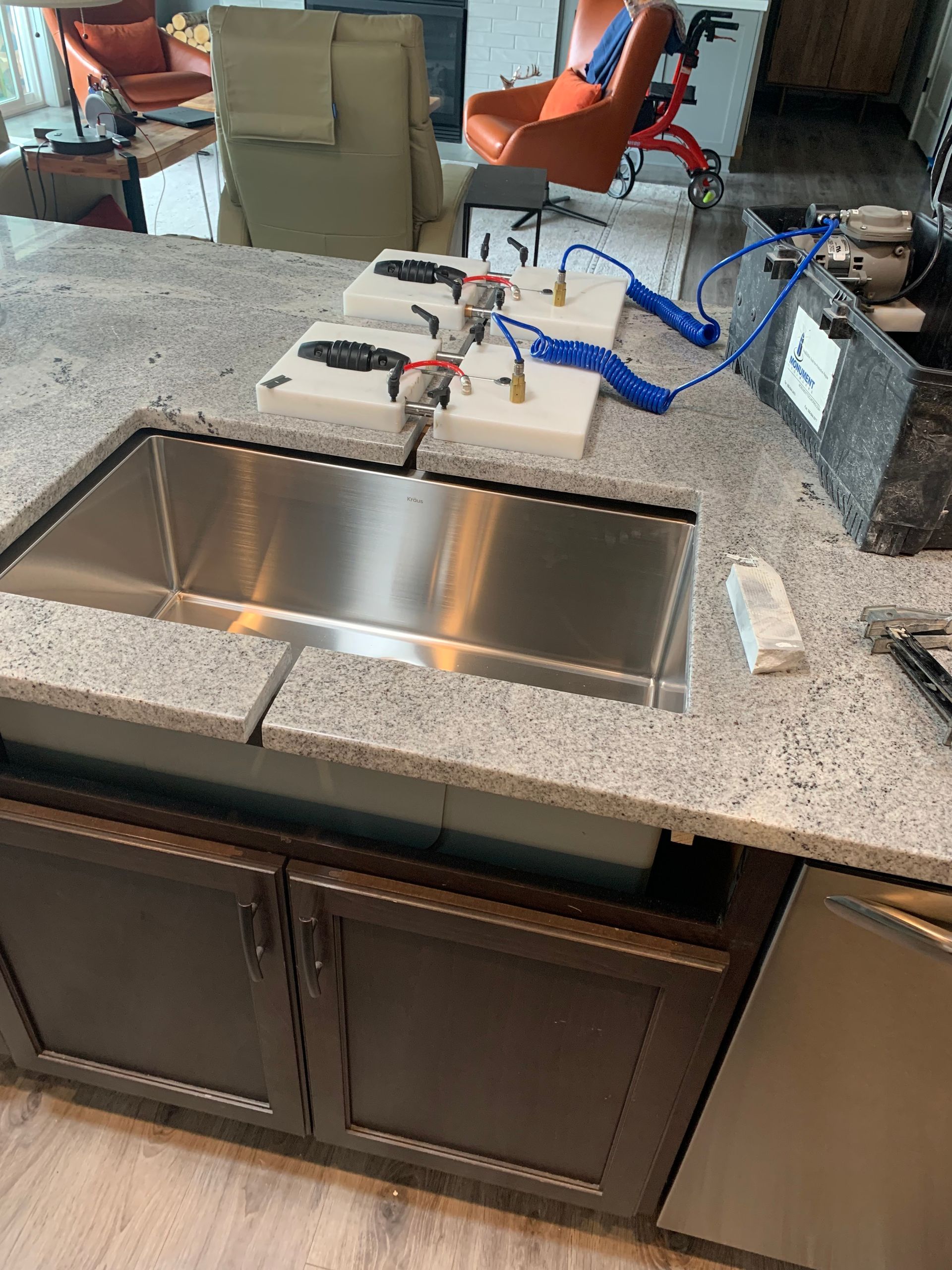 Kitchen remodel in progress: white cabinets, granite countertops, stainless steel appliances, and dark flooring.