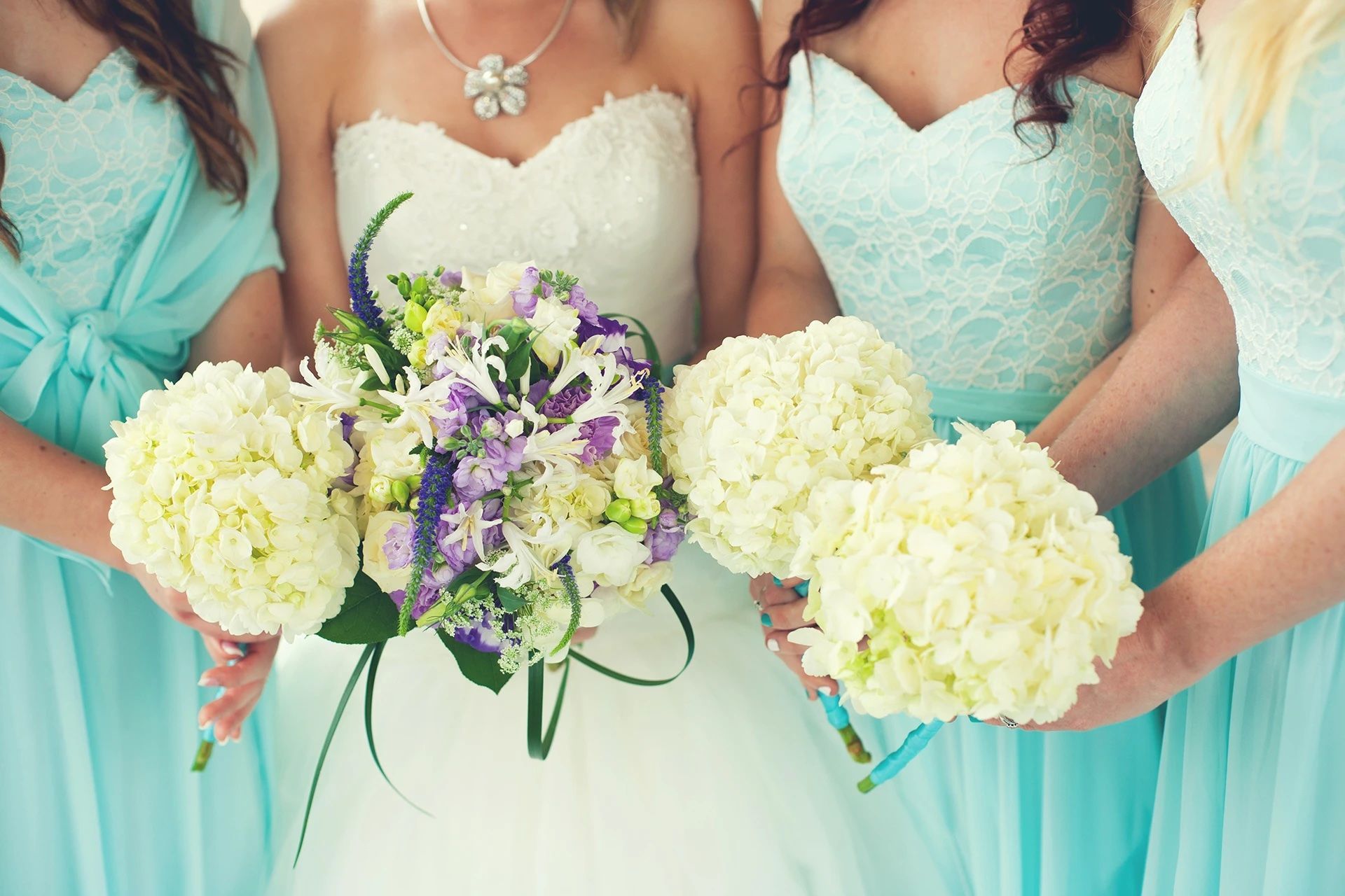 Une mariée et ses demoiselles d'honneur tiennent des bouquets de fleurs.
