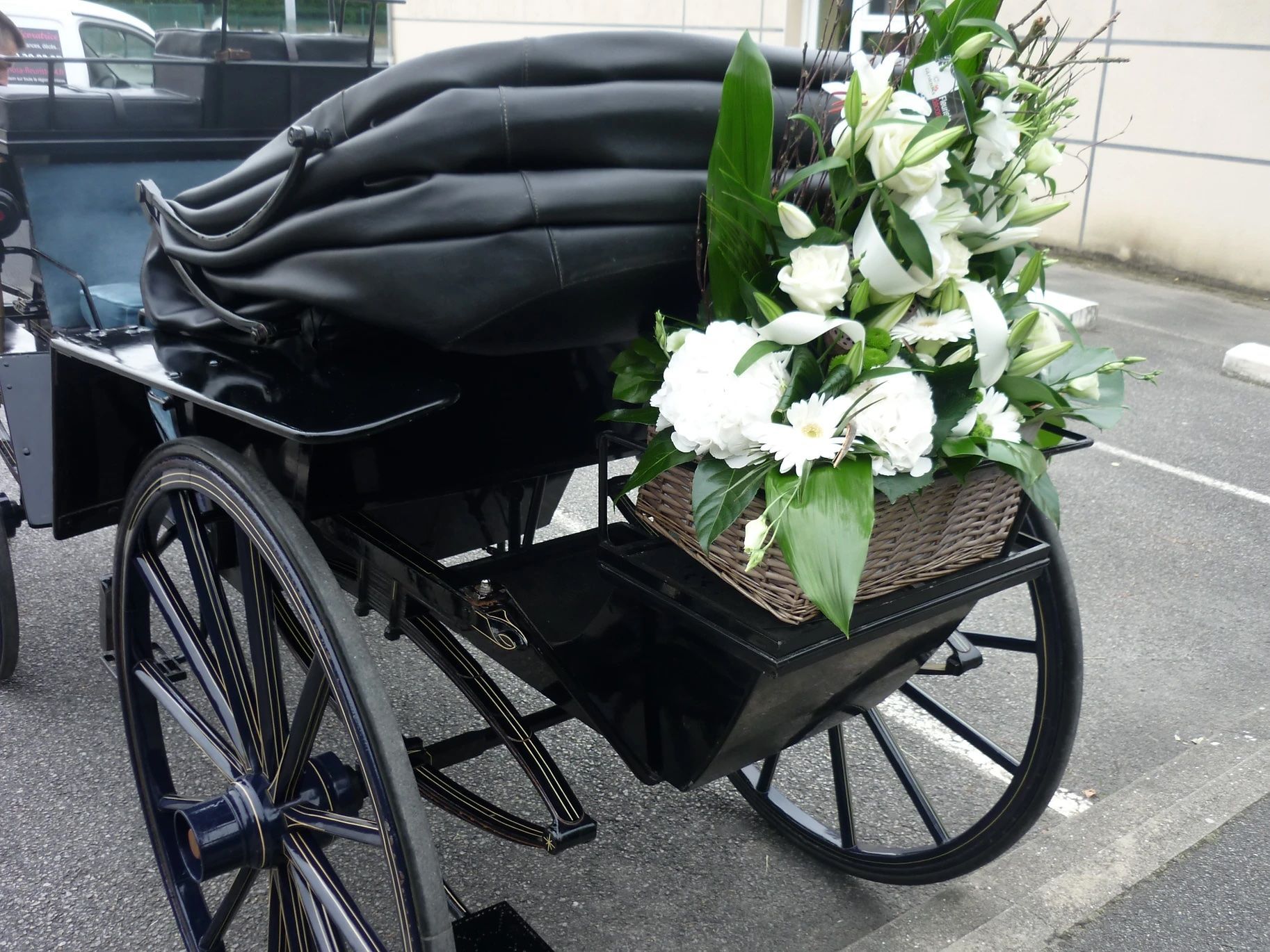 Une calèche avec un panier de fleurs à l'arrière