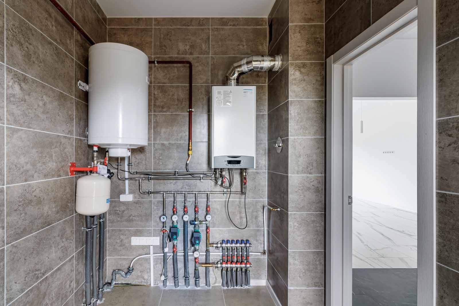 A bathroom with a boiler and a water heater.