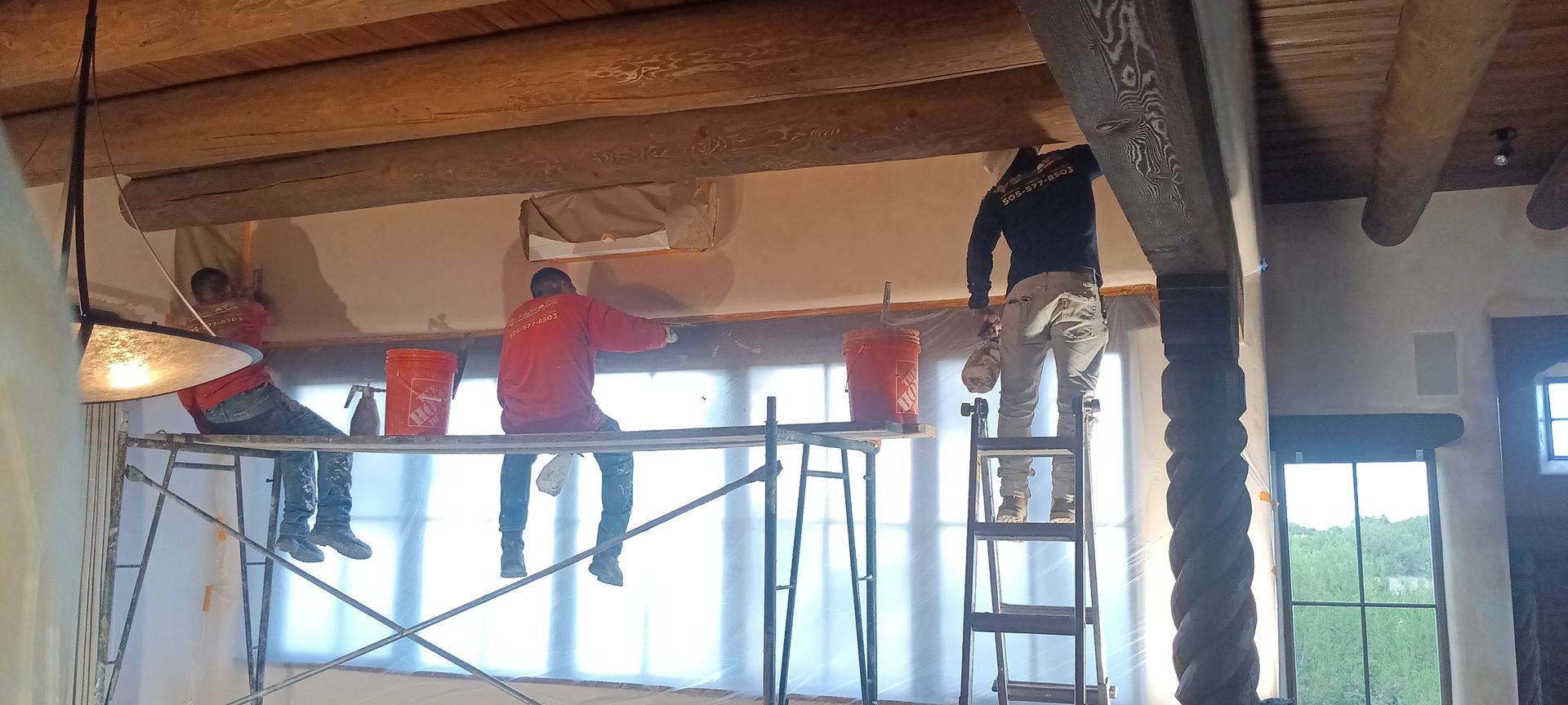 A man is painting a wall with a sprayer