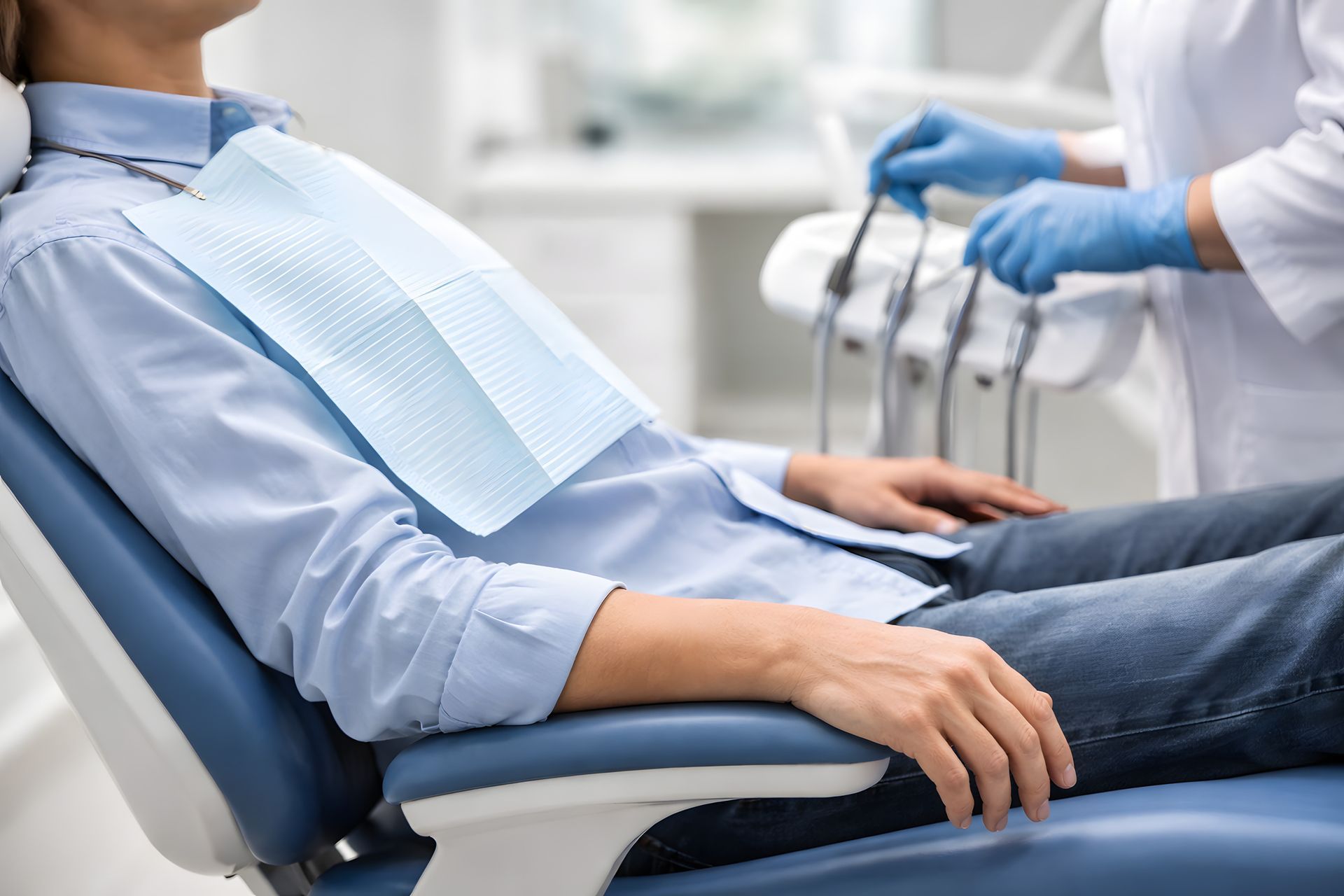 Patient in dental chair during dental visit, face not visible. Patient in dental chair during dental visit, face not visible.