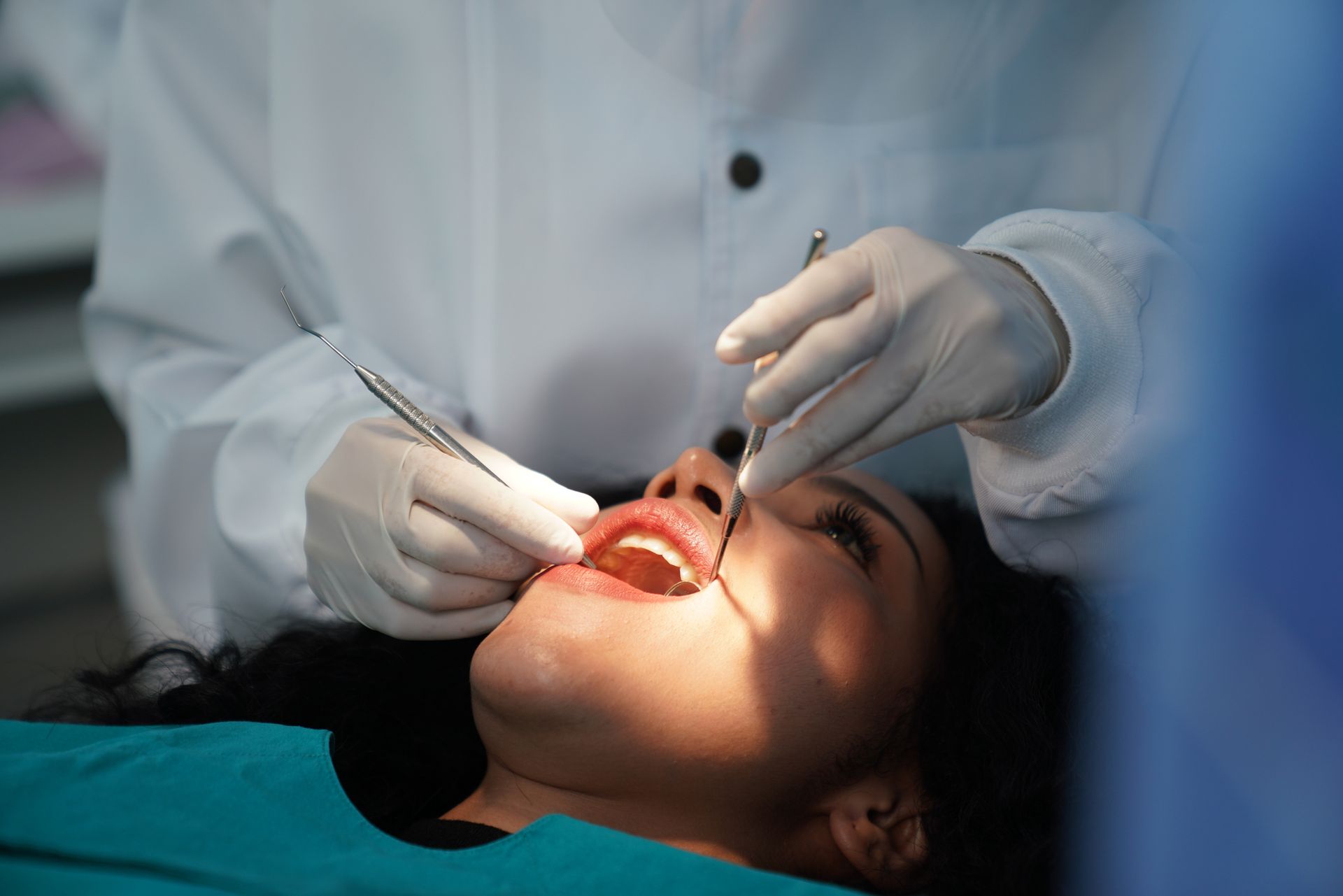 Dentist examines patient's mouth during procedure.