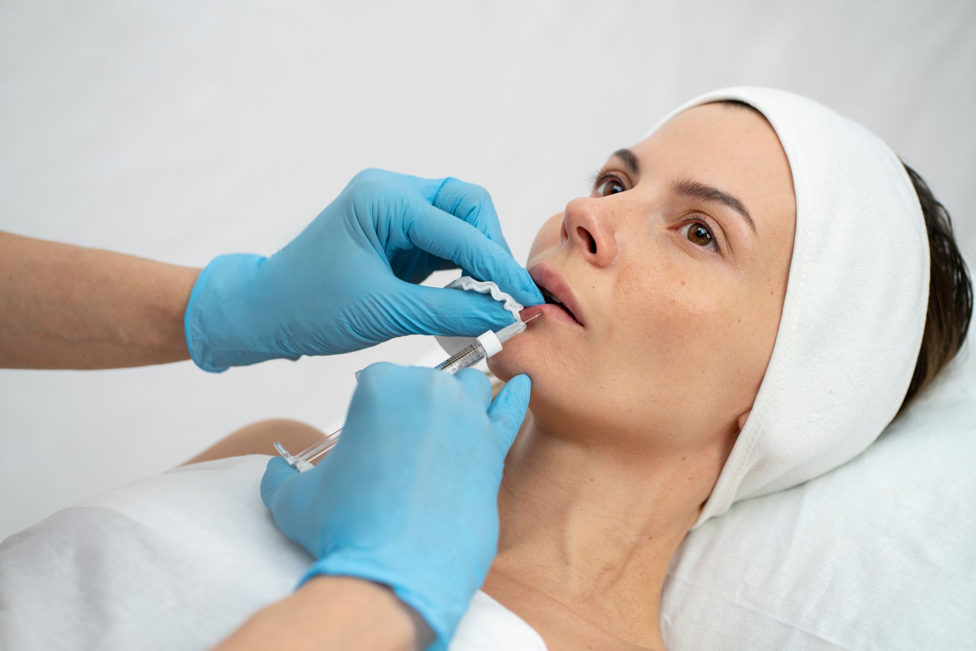 a woman is getting a botox injection in her lips
