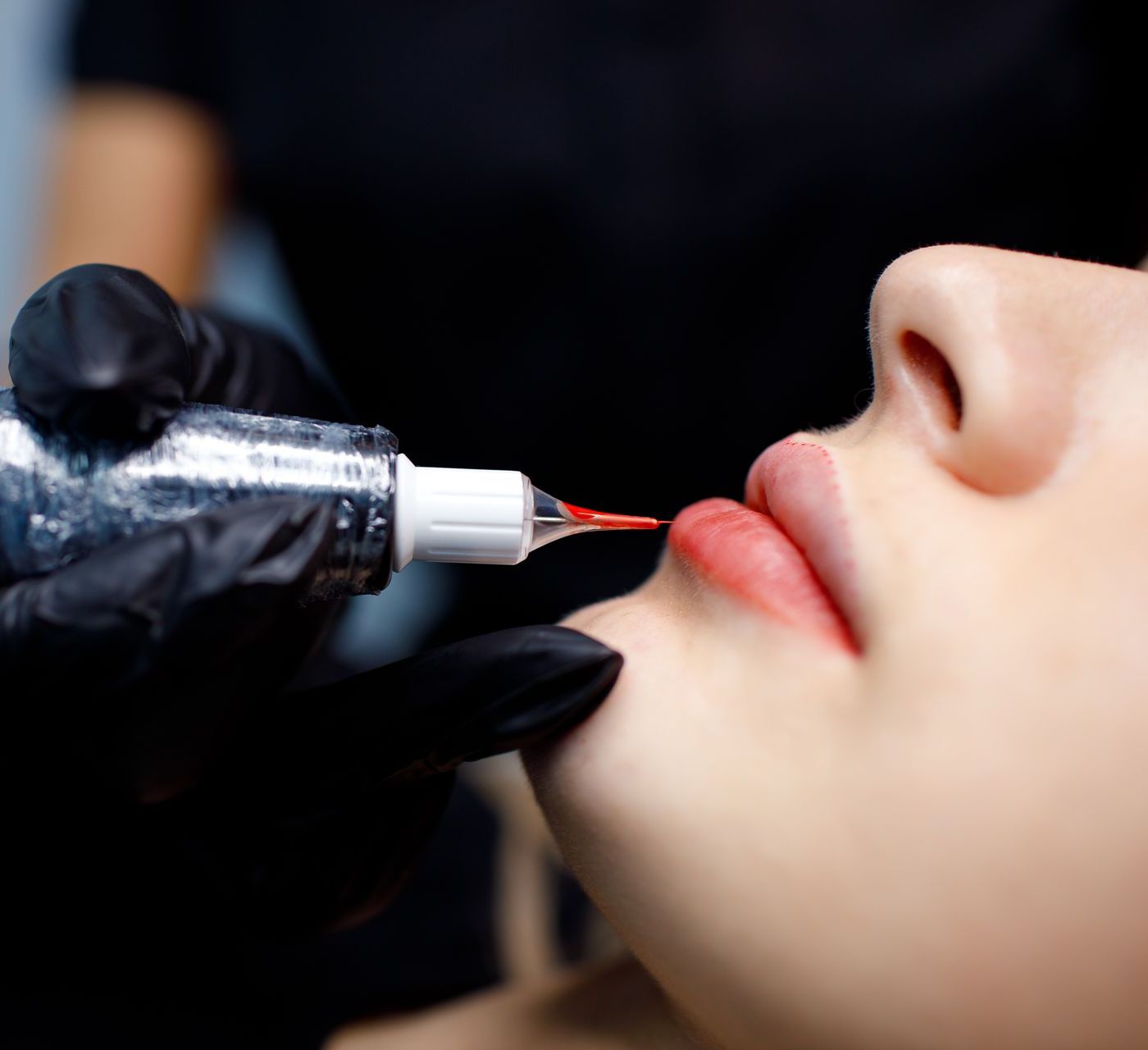 a woman is getting a tattoo on her lips