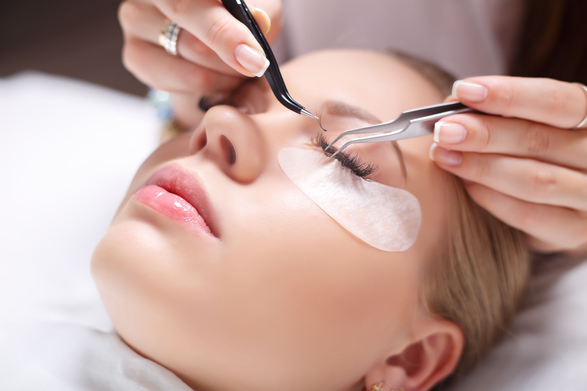 a woman is getting her eyelashes done at a beauty salon