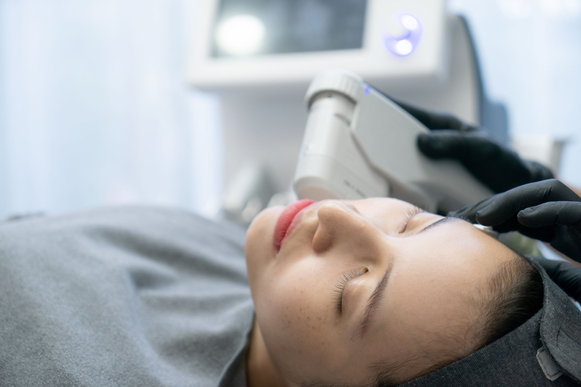 a woman with her eyes closed is getting a treatment on her face