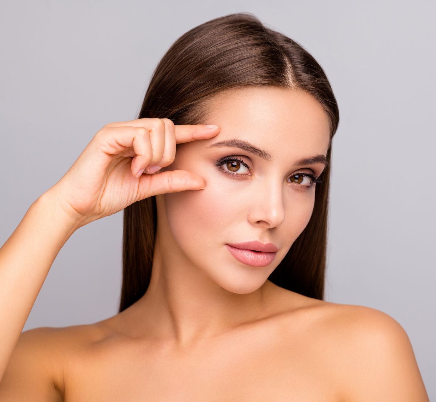 a woman is touching her eyebrow with her finger