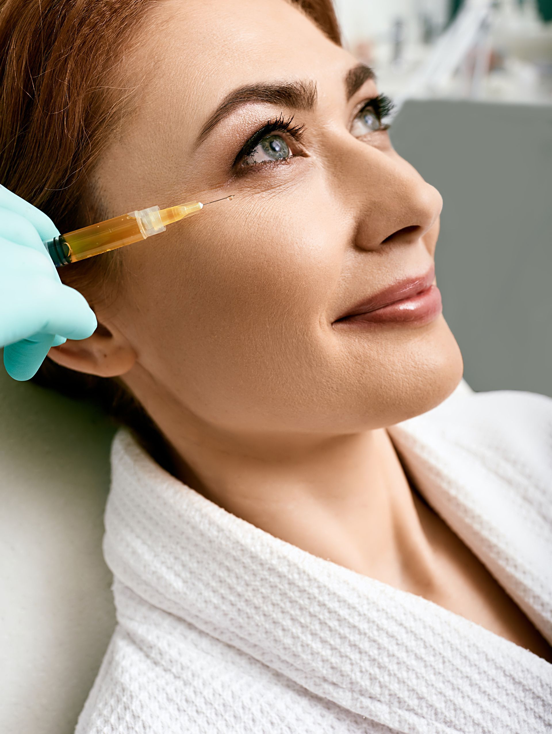 a woman with her hands on her chin looks at the camera