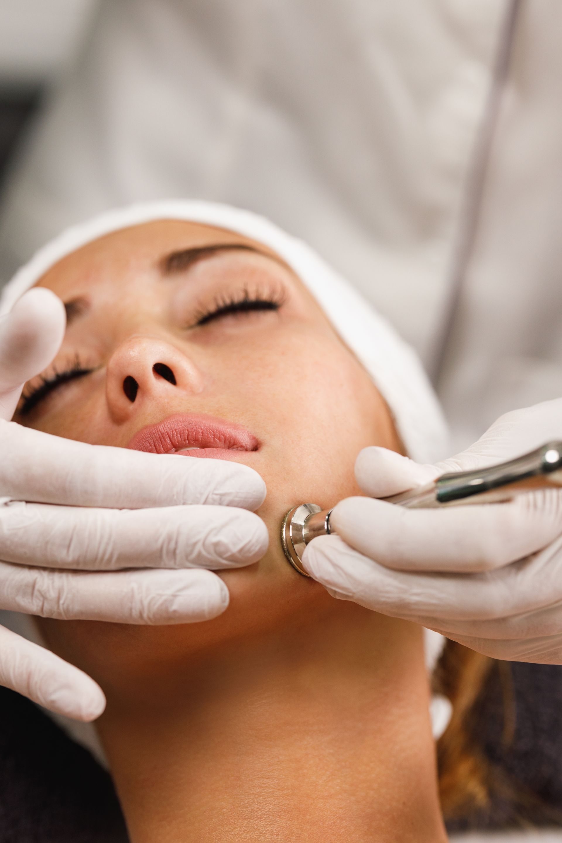 a woman with her eyes closed is getting a facial treatment
